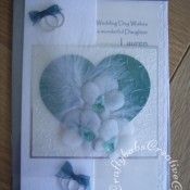 Feathers & Orchids Wedding card. Orchids hand cut and embossed in parchment, Dies used include Sizzix originals Hearts dies, Cuttlebug divine swirl embossing folder and Sizzix sizzlits wedding rings die. - craftybabscreativecrafts.co.uk