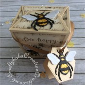 Bee Happy boxes made using: the Memory Box Small Takeout Box die, the Bee die from The Indigo Blu mixed media Special magazine kit issue one multicut from yellow, black and white card stock, the small bee die and Bee happy stamp from the free cover gift of Issue 163 of Papercraft Essentials magazine . The tag was made using a die from a set of nesting hexagons dies. The glittered patterned paper was from the Docrafts Premium 12" Bee Happy paper pad. I added stickles glitter and glossy accents to the larger bees. - craftybabscreativecrafts.co.uk
