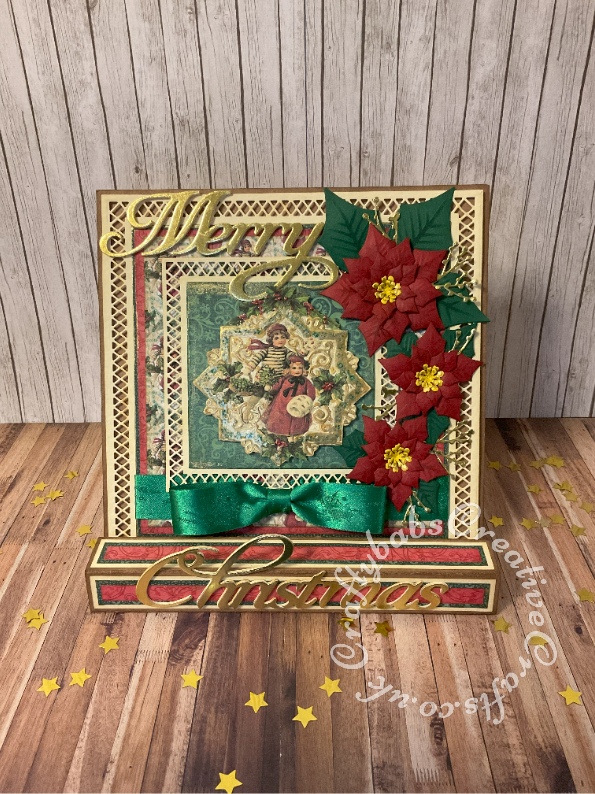 Vintage style 8" x 8" square box easel card made using papers and toppers printed from Joanna Sheen 'Enchanted Christmas' CD Rom and Hot Off The Press 'Vintage Christmas' CD Rom and various dies including: Paper discovery card builder nested square dies, Spellbinders shapeabilities poinsettia dies, unbranded berry sprig dies and Quickutz Cookie cutter dies 'Merry Christmas'. mats and layers enhanced with gilding wax. Topper enhanced with Glossy Accents and gilding wax. - craftybabscreativecrafts.co.uk