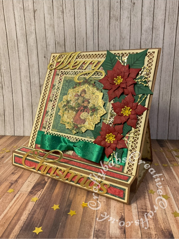 Vintage style 8" x 8" square box easel card made using papers and toppers printed from Joanna Sheen 'Enchanted Christmas' CD Rom and Hot Off The Press 'Vintage Christmas' CD Rom and various dies including: Paper discovery card builder nested square dies, Spellbinders shapeabilities poinsettia dies, unbranded berry sprig dies and Quickutz Cookie cutter dies 'Merry Christmas'. mats and layers enhanced with gilding wax. Topper enhanced with Glossy Accents and gilding wax. - craftybabscreativecrafts.co.uk